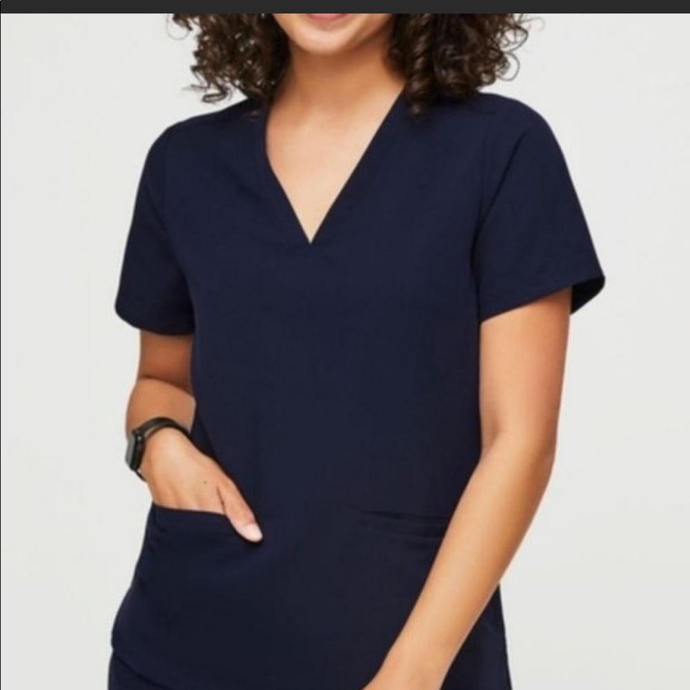 Figs Women’s black scrub top.  Technical collection.  Two front pockets.